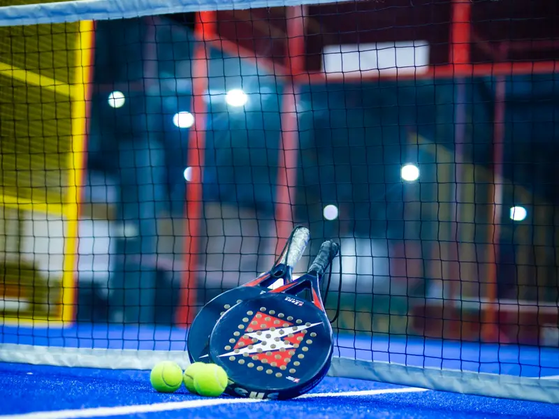 Padel rackets and balls by the net