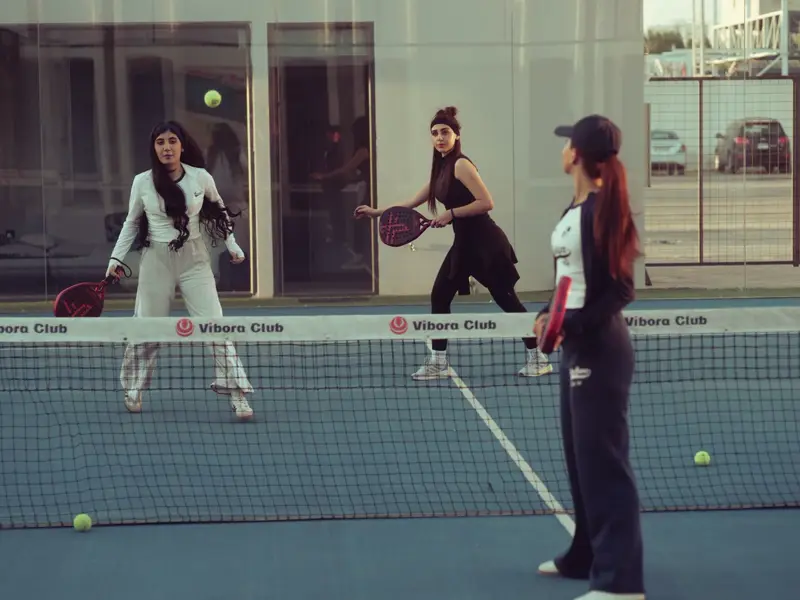 Players in a padel match at the net
